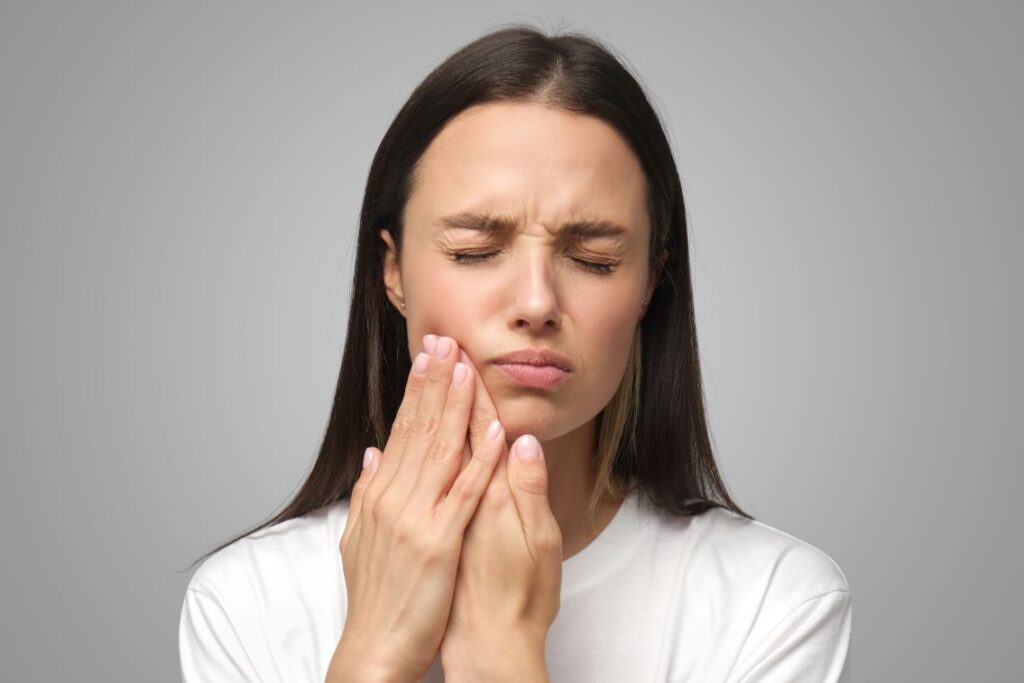 A woman experiencing pain from clear aligners.