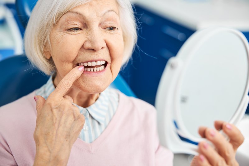 a patient checking her tooth with a mirror