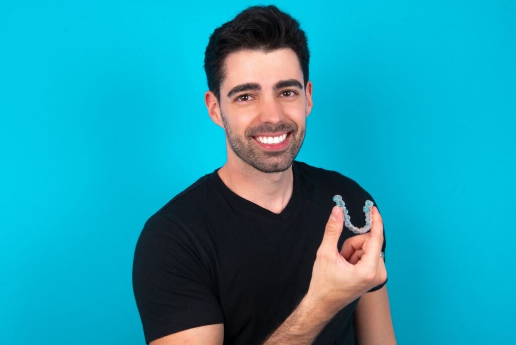A man holding a Candid Pro Clear Aligner